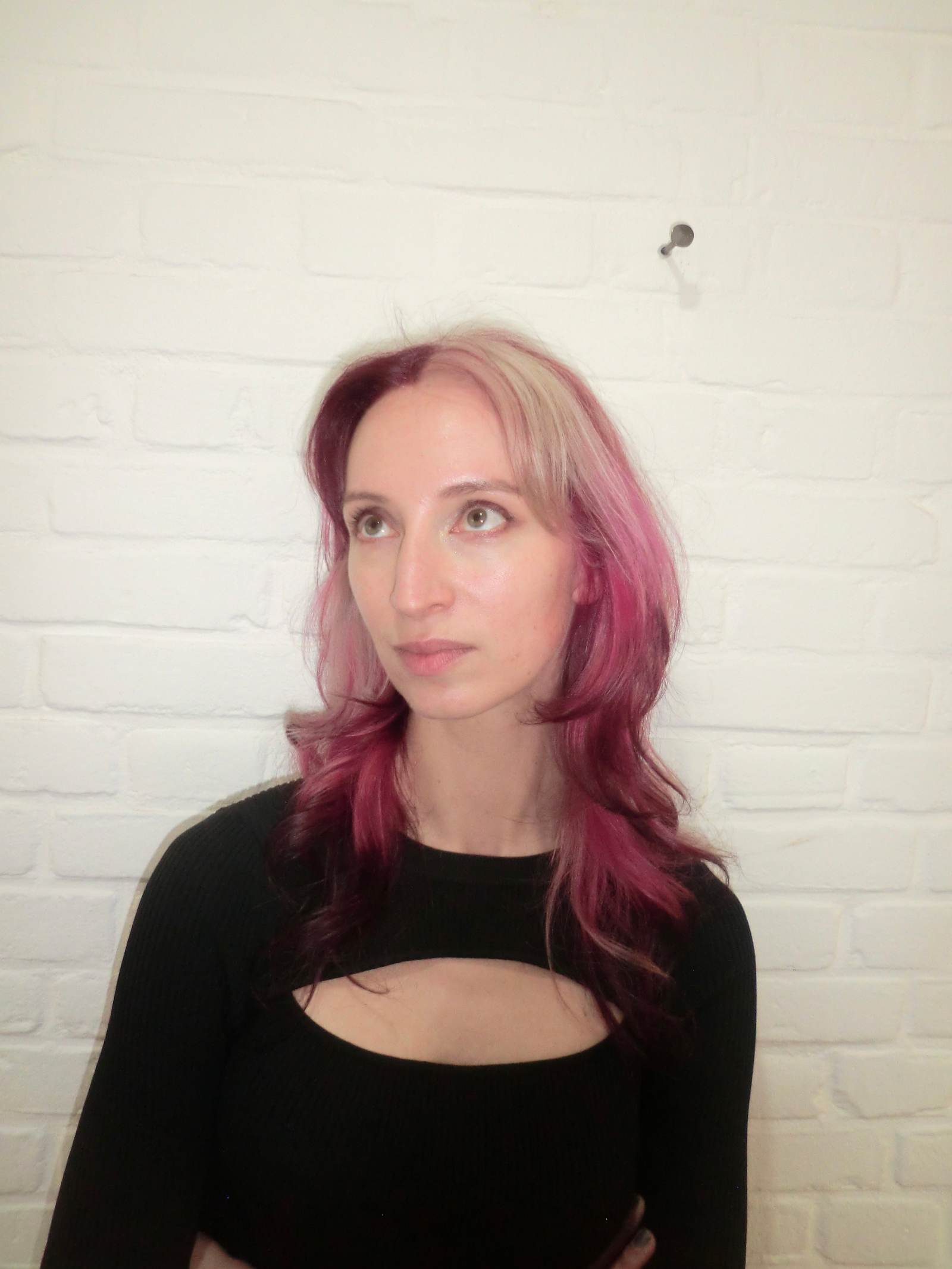 A back view of a high-impact colorblocking hair design. The hair is divided into distinct, bold sections of metallic silver, vibrant hot pink, and deep crimson red. The colors are applied in large, clean blocks that contrast sharply against one another, creating a modern, graphic art effect across the straight lengths.