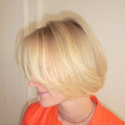 A back view of a chin-length layered bob. The cut features various lengths throughout the hair to add movement, volume, and a soft, textured finish rather than a blunt edge.