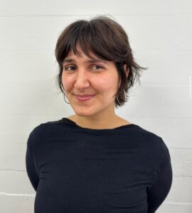 A side view of a "bixie" cut, a hybrid between a pixie and a bob. The hair features the shaggy layers of a pixie but maintains the length of a short bob around the ears and nape, creating a soft, voluminous shape.