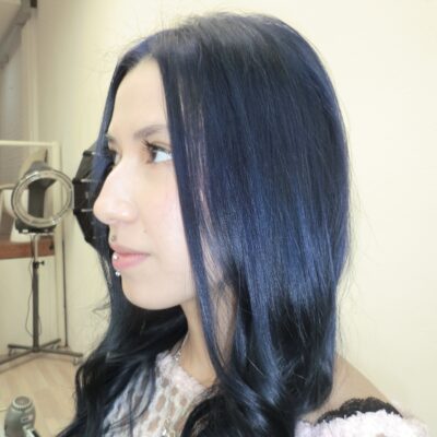 A side view of the same hair, now dyed a deep, saturated dark blue. The color is a consistent midnight navy tone from roots to ends, styled to show off the hair's natural texture and the new cool-toned hue.