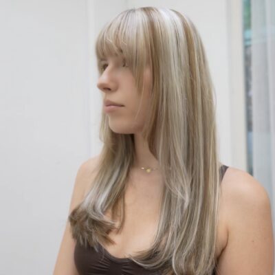 A side profile view of the same long, below-the-chest hair, transformed with high-contrast color. The base is a deep, cool-toned brunette interwoven with thick, chunky metallic silver highlights. The large sections of silver pop sharply against the ash brown background, styled straight to emphasize the bold color-blocked lines.