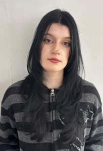 A close-up showcasing hair styled with distinct, feathered layers that create volume and movement. The ends are flicked outward to emphasize the tiered texture and flow of the cut.